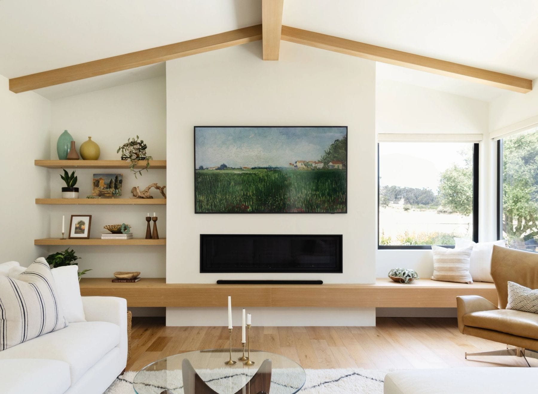 Living room with a vaulted ceiling, built-in wood bench, and a linear fireplace.